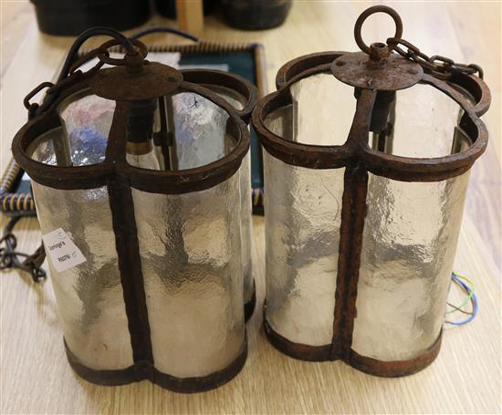 A pair of wrought iron and glass lanterns